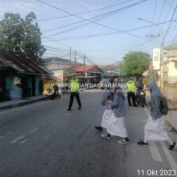 Satlantas Polres Kepulauan Aru Gaur Pagi Sambil Bantu Anak Sekolah Menyeberang Jalan.