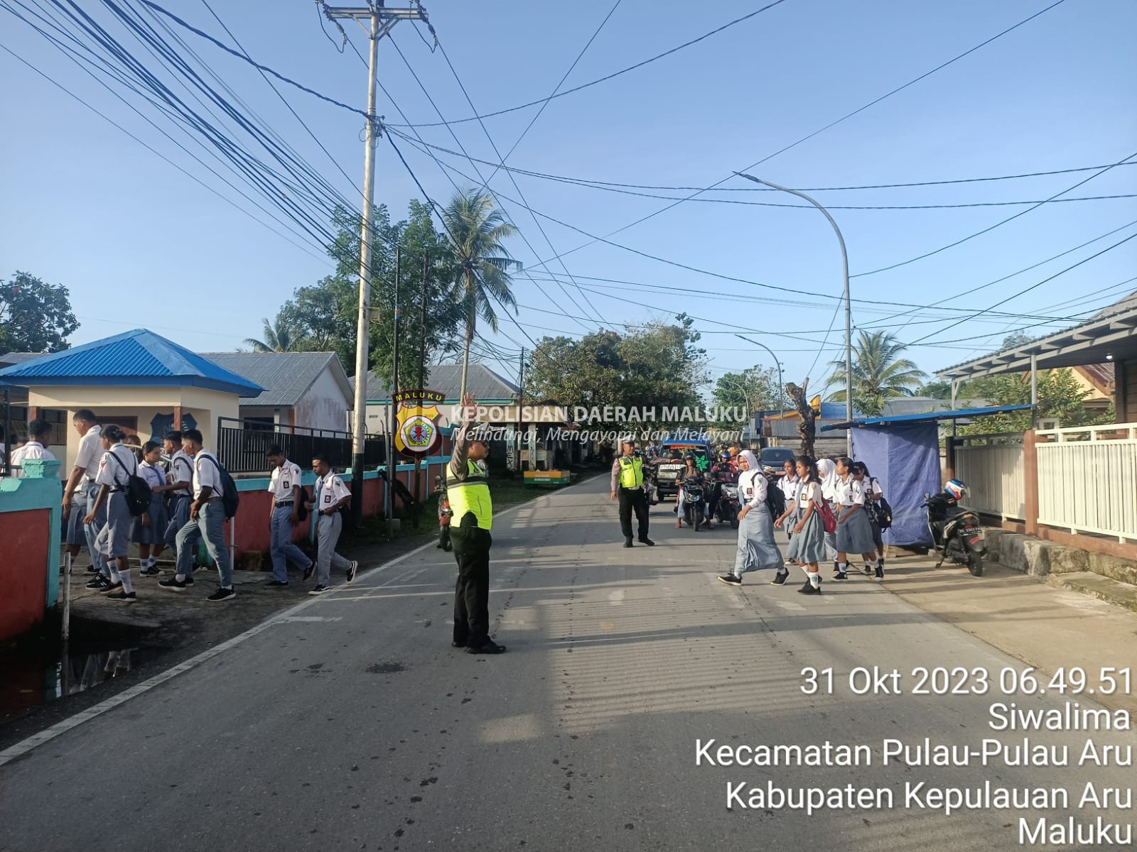 Wujud Kepedulian, Personel Sat Lantas Polres Kepulauan Aru Bantu Anak Sekolah Menyebrang Jalan.