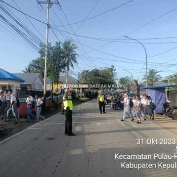 Wujud Kepedulian, Personel Sat Lantas Polres Kepulauan Aru Bantu Anak Sekolah Menyebrang Jalan.