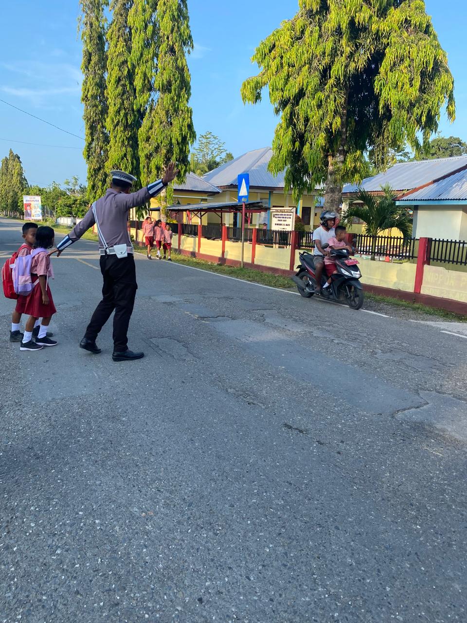 Beri Rasa Aman dan Nyaman, Polisi Bantu Anak Sekolah Menyeberang Jalan